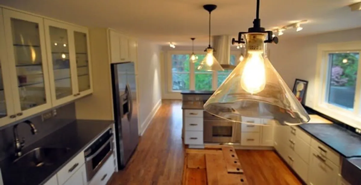 Residential electrician installing modern indoor light fixture in a home in Chandler, AZ